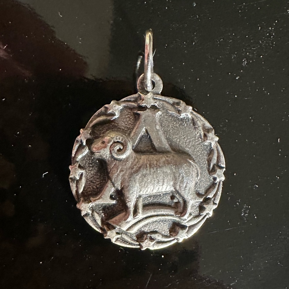 Aries zodiac symbol pewter pendant, size of a U.S. quarter.